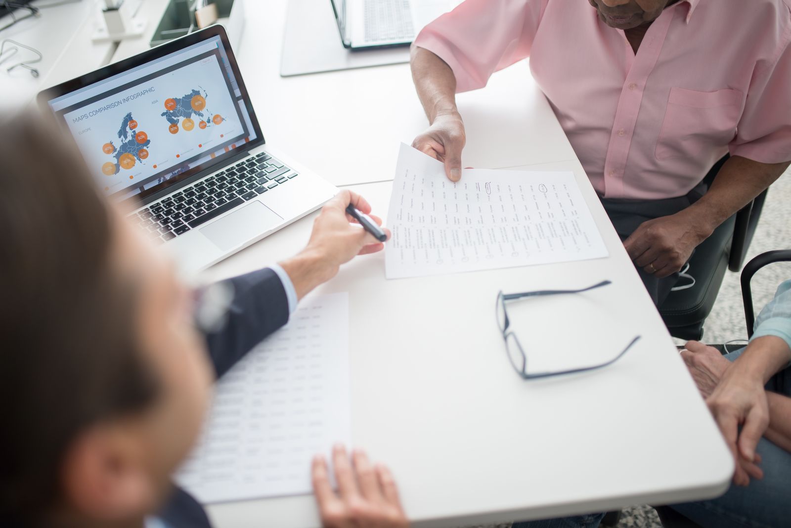 A senior couple reviewing paperwork with a professional at a desk